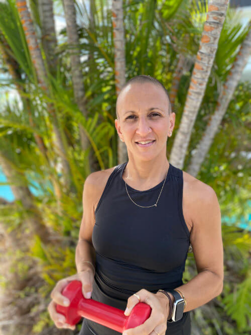 Suzanne in a black gym top holding a red weight